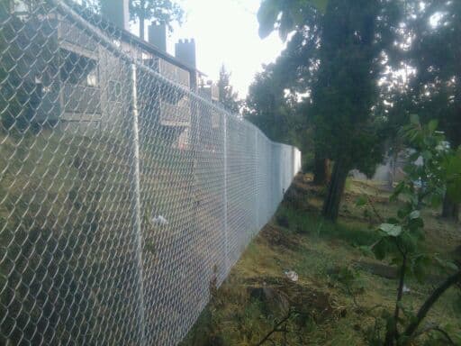 Tall chain link fence along hillside