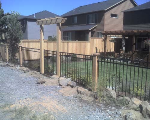 Metal fence with cedar posts and arbor